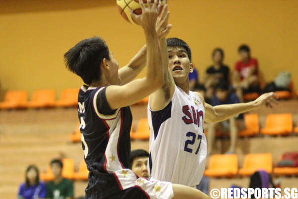 Ng Han Bin (SIM #27) trying to block Wee Hui Xiang (SMU #6) as he goes to the basket