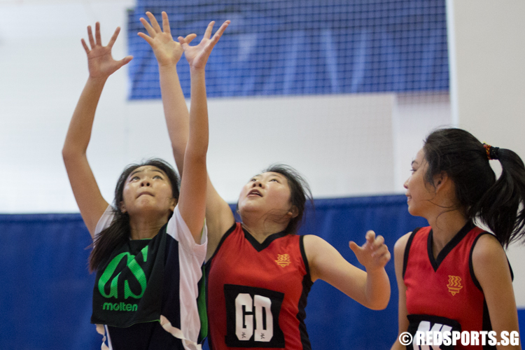 Pattany (GS) of Saint Andrew’s Junior College and Sabrina Chin (GD) of Hwa Chong Institution reaching for the ball. (Photo © Lee Jian Wei/Red Sports)