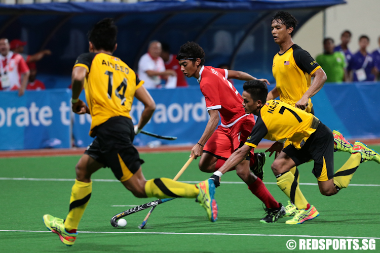 Haseef Salim (#2) of Singapore dribbles the ball against Malaysia. (Photo © Lee Jian Wei/Red Sports)