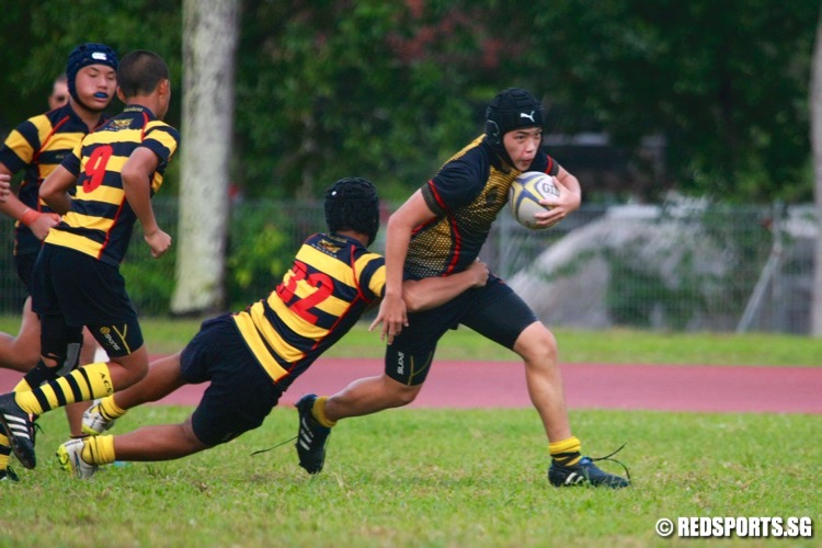 An ACS (Barker) gets tackled by Azhar (#32) of ACS(I). (Photo © Les Tan/Red Sports)