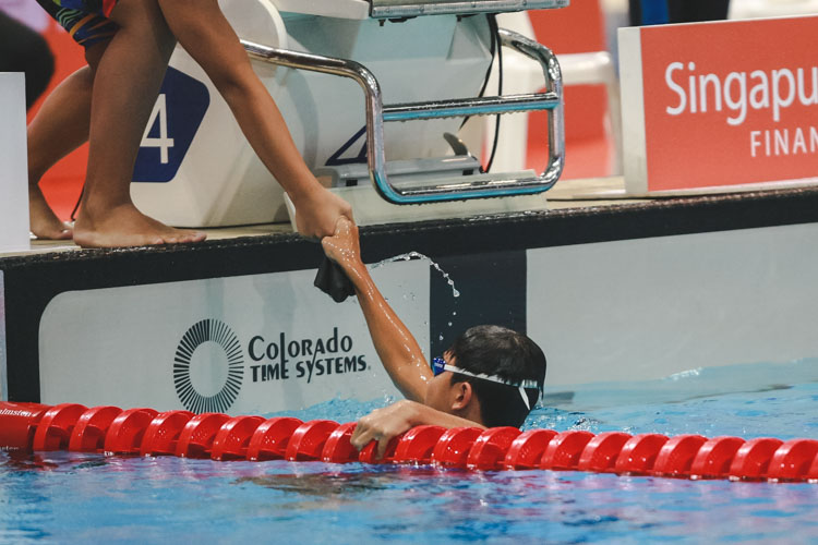 Christian Low receives a congratulatory handshake from his teammate after he finished first in his heat. He came in second with a final timing of 5:18.45. (Photo 4 © Soh Jun Wei/Red Sports)