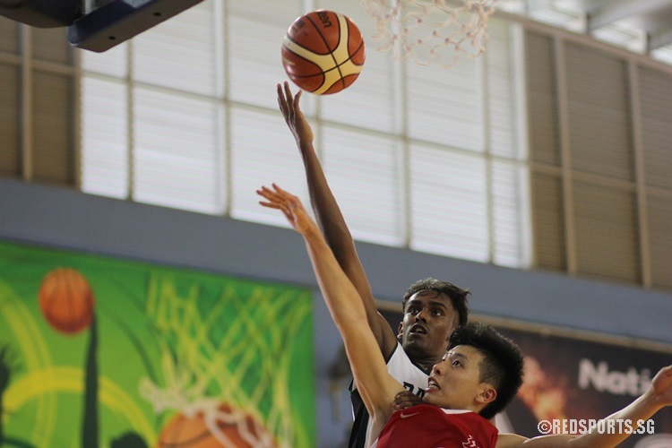 Vignesh Renagarajan (RI #11) goes for a layup while being pressured by his opponent.