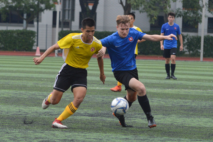 Marcus Tang (VJC #5) and Banbury Lee (#NYJC #12) battle for the ball. (Photo 3 © REDintern Nathiyaah Sakthimogan)