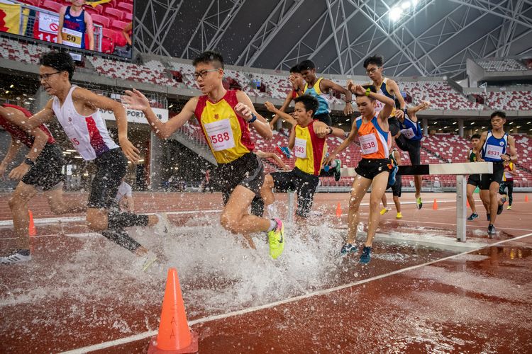 The B Division boys at the water jump of the 2000m steeplechase final.