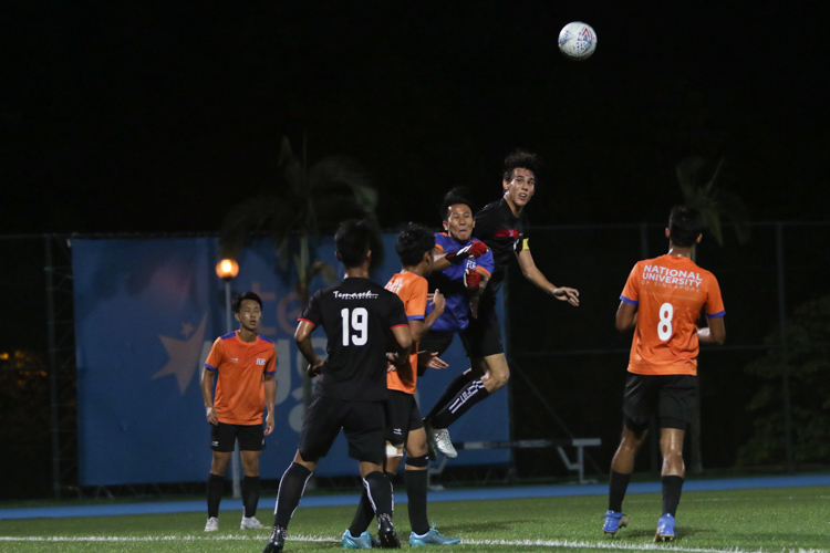 NUS keeper Teo Guan Kai Gabriel (#18) punches the ball clear in an aerial contest with TP captain Mahler Jacob William (#17). TP edge out NUS 2-1 to claim IVP Football championship. (Photo 3 © Clara Lau/Red Sports)