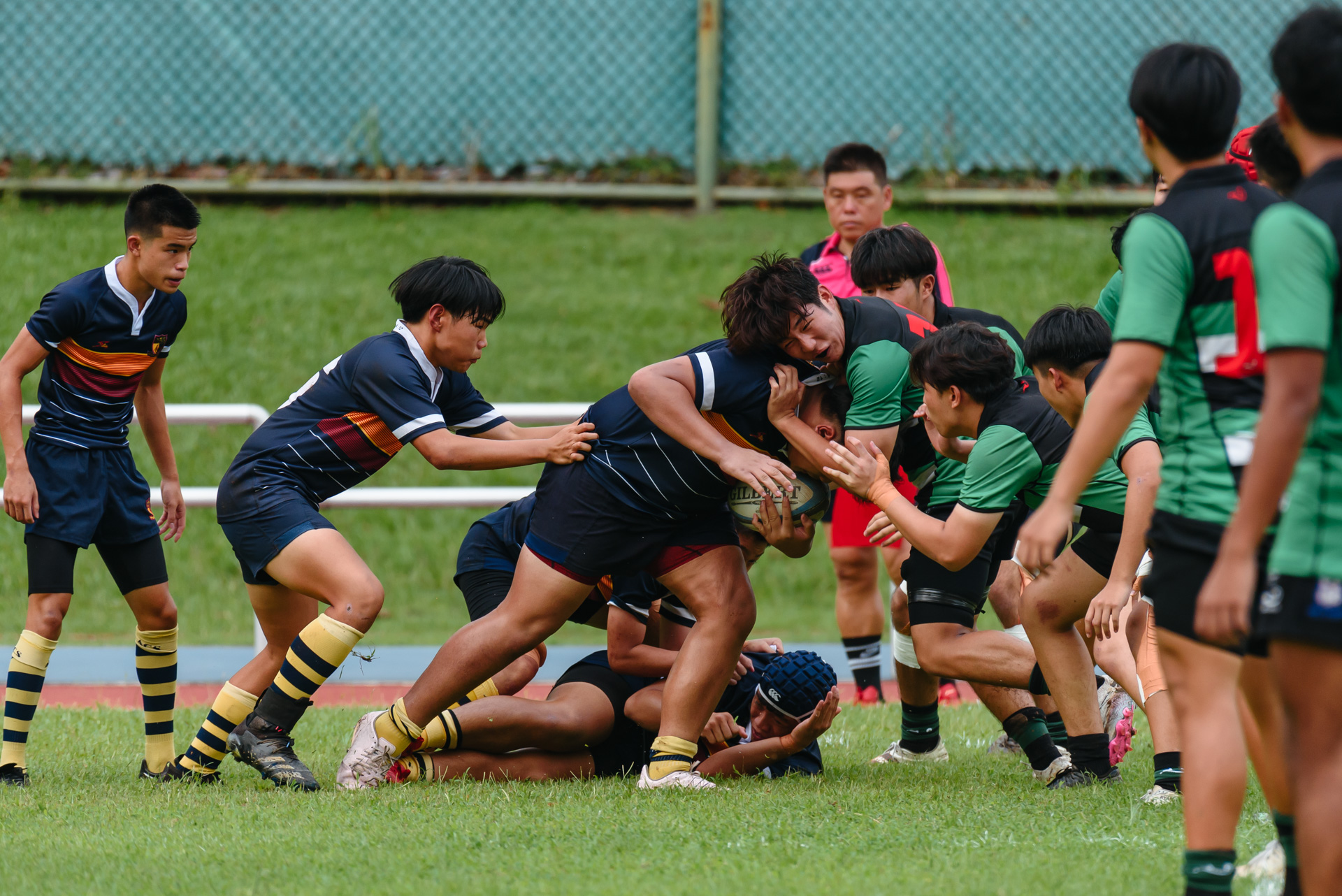 ACJC’s Darrian Shaedon (#01) carries hard into the tackle of RI’s Jin Junzhong (#15). (Photo 3 © Jared Chow/Red Sports)
