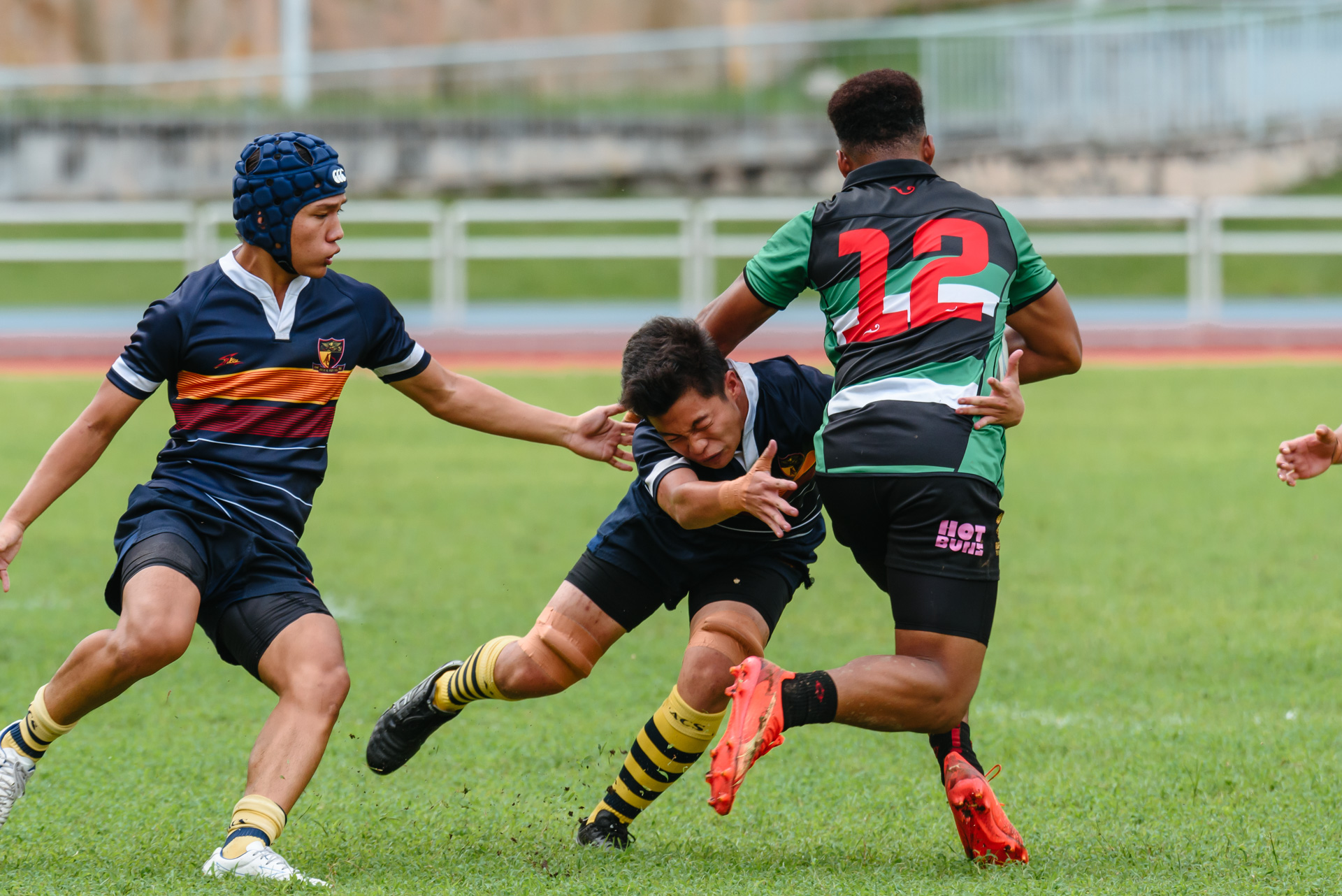 RI’s Olayemi Olaniyan (#12) attempts to fend off the tackle by ACJC’s Ethan Koh (#12). (Photo 4 © Jared Chow/Red Sports)