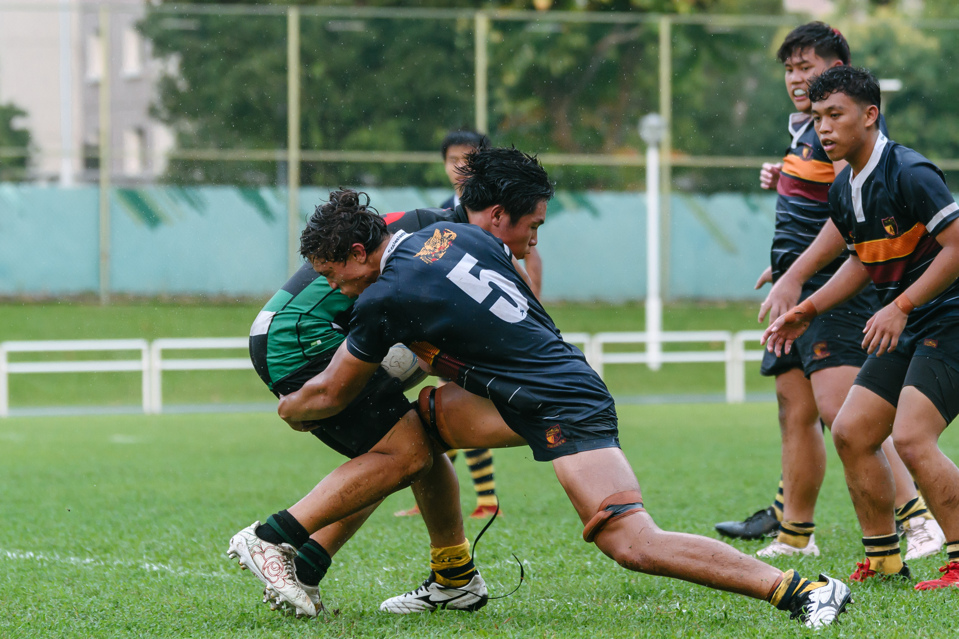 ACJC’s Lukas Andersen (#5) bursts out of the line to make a strong tackle. (Photo 14 © Joash Chow/Red Sports)