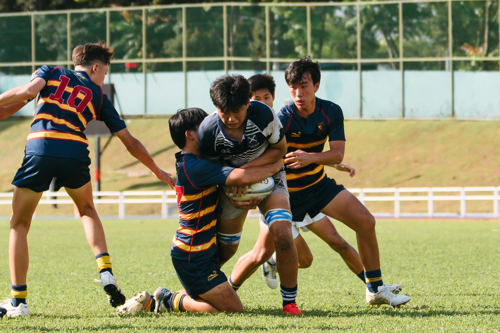 A St. Andrew’s player gets dragged down by an ACS(BR) tackler. (Photo 3 © Joash Chow/Red Sports)