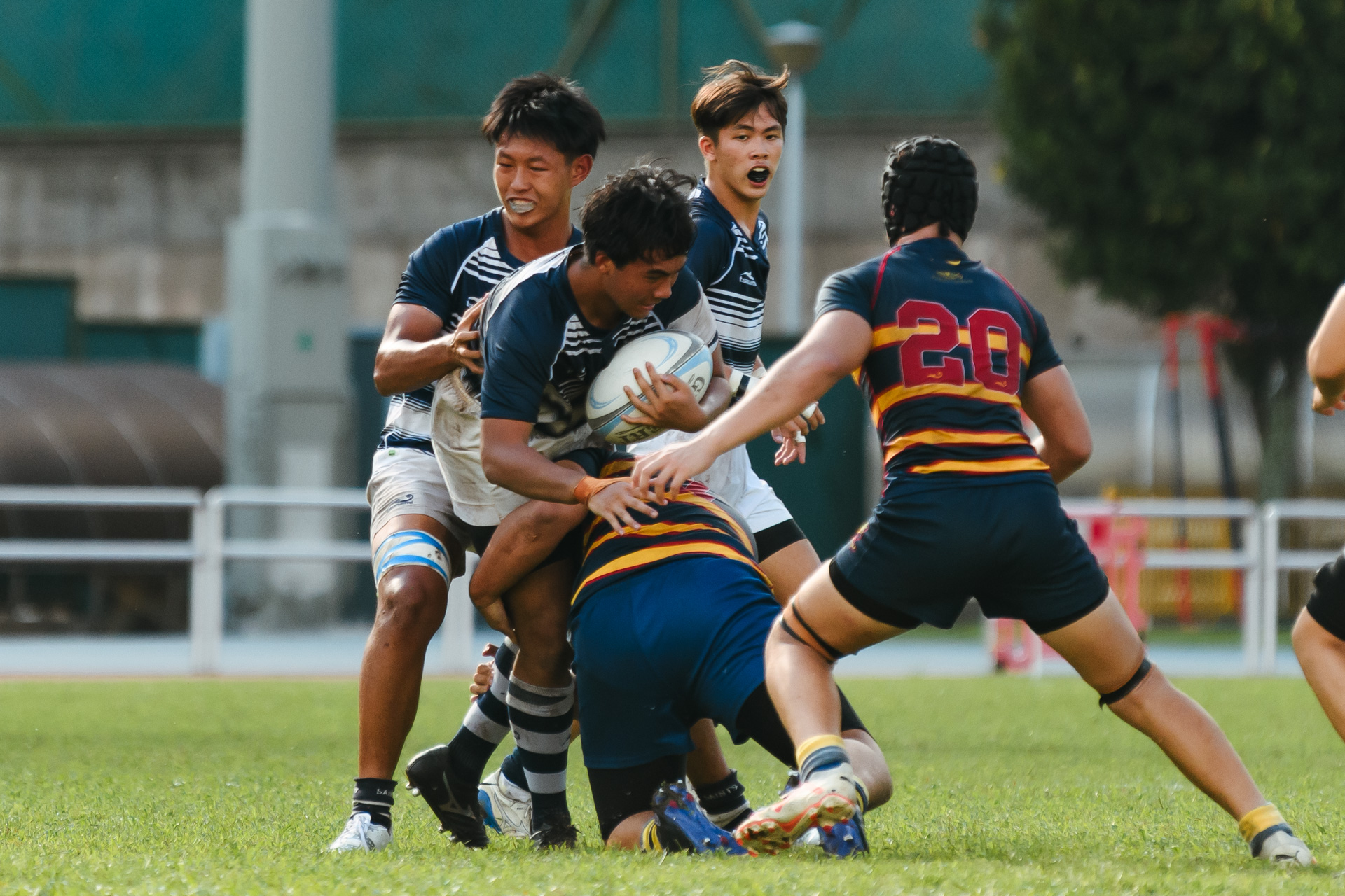 An ACS(BR) player makes a low tackle against the SA ball-carrier. (Photo 5 © Joash Chow/Red Sports)