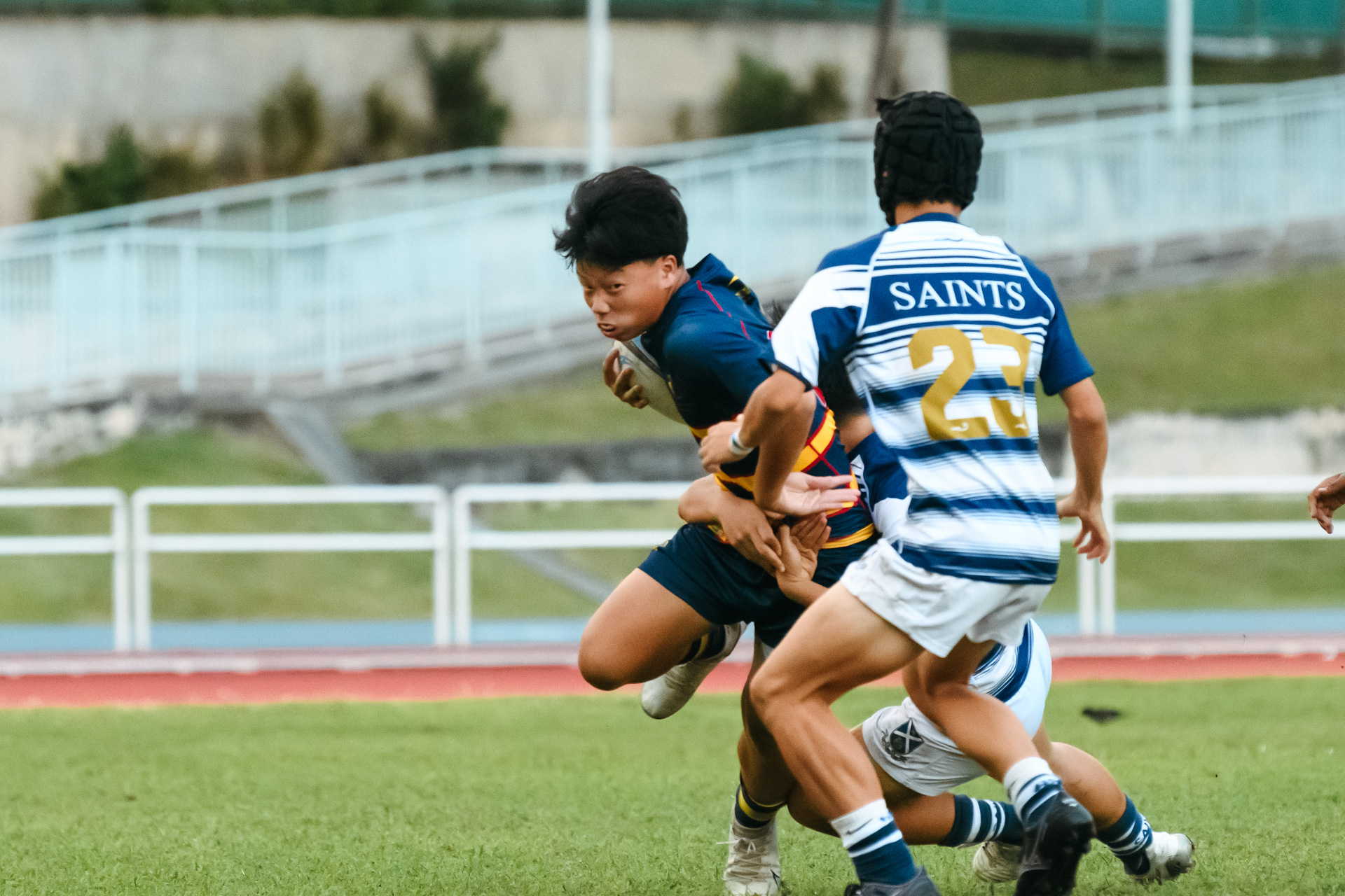 An ACS(BR) player attempts to wriggle out of a tackle. (Photo 15 © Joash Chow/Red Sports)