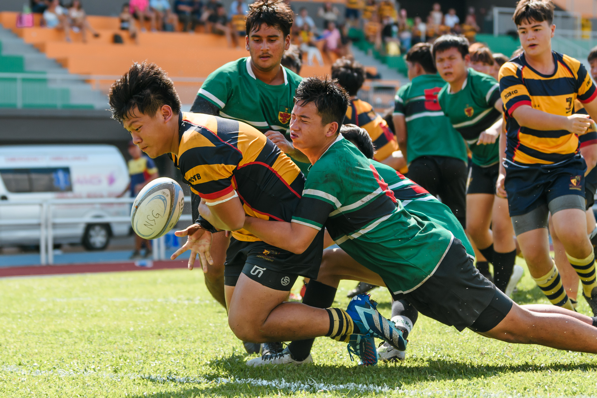 ACS(I)’s Ames Leung (AC #1) spills the ball over the try line while caught in the tackles of RI’s Ashton Yong (#6) and Gregory Wee (#30). (Photo 17 © Joash Chow/Red Sports)