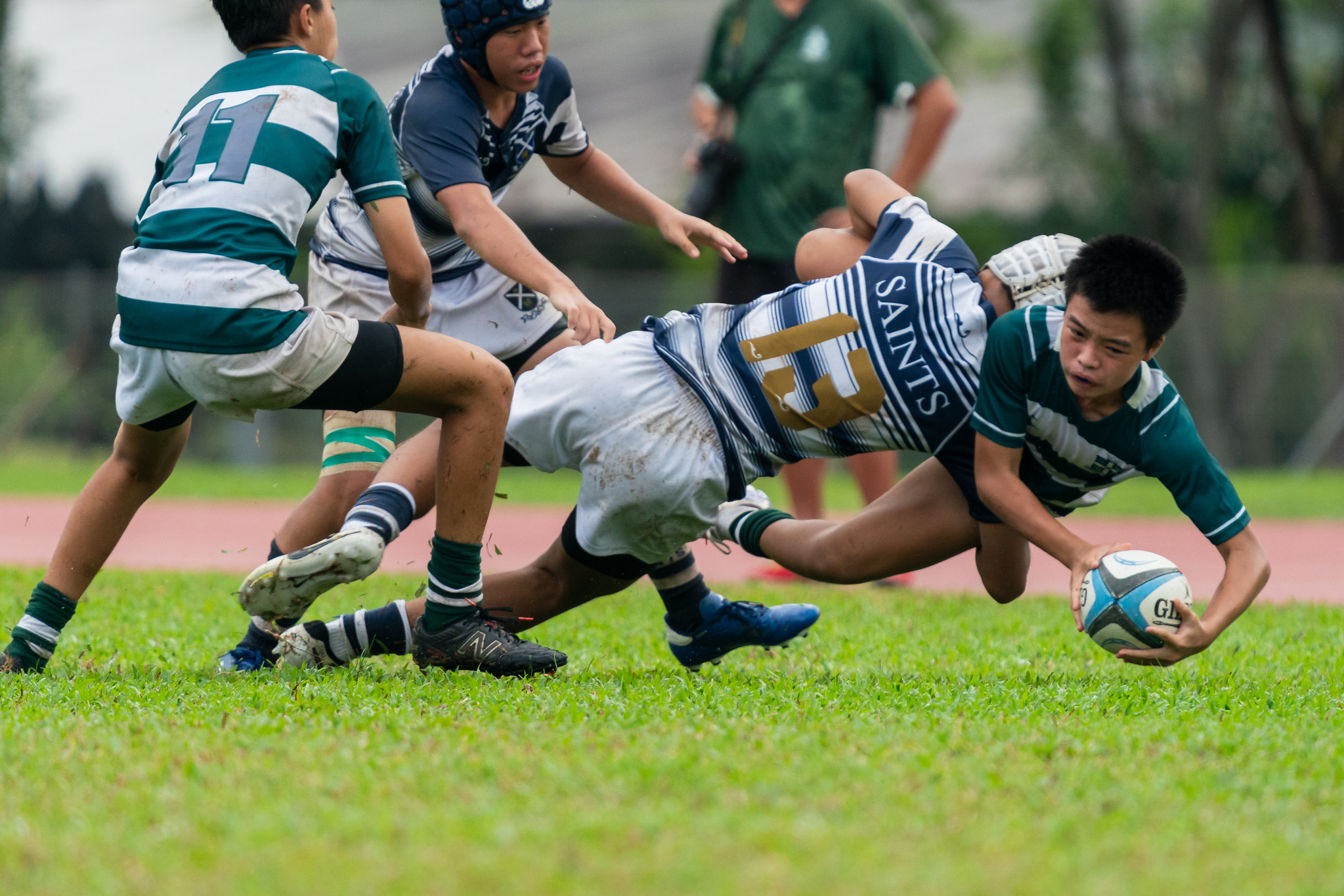 Zachary Ang (SJI#21) attempts an offload in-tackle (Photo 7 © Bryan Foo/Red Sports)